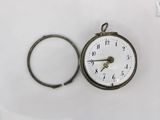 a pocket watch with a ring around it on a white surface