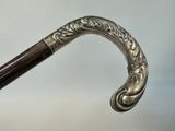 a close up of a silver cane with a wooden handle