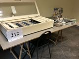 une table sur laquelle se trouve une machine à voter, dans une pièce