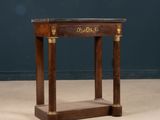 an antique wooden table with a marble top and two columns