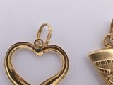 two pieces of gold plated metal with a heart and an egyptian boot