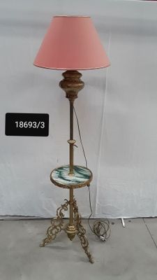 a lamp that is on a stand with a pink shade