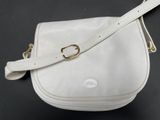 a white purse with a gold buckle on it