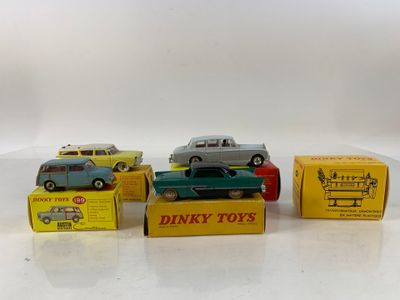 four toy cars are lined up in a row on a white surface