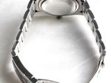 a close up of a watch on a white surface