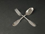 deux cuillères et une fourchette posées sur une table noire