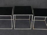 three black and silver nesting tables on a black background