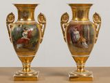 deux vases en or ornés de peintures, posés sur une table
