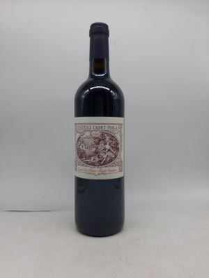 la bouteille de vin rouge est posée sur une surface blanche
