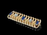 gros plan d'une bague en or avec saphirs et diamants
