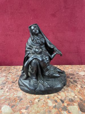 a statue of a woman sitting on top of a rock