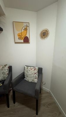 deux chaises dans un coin d'une pièce où est accroché un tableau au mur