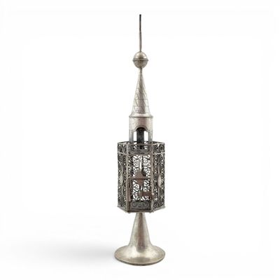 a silver metal object with a tall tower on top of it