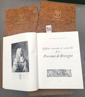 un livre ouvert posé sur une table, à côté d'un tableau en liège