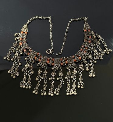 a close up of a necklace on a table with a black background