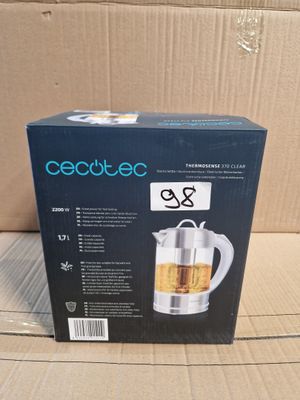 emballage d'une théière en verre posée sur une boîte en carton