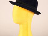 tête de mannequin jaune coiffée d'un chapeau noir