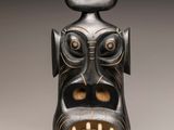 an image of a black and gold vase with a face on it