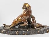 sculpture en bronze représentant un lion de mer et un bébé phoque, posée sur un socle en marbre