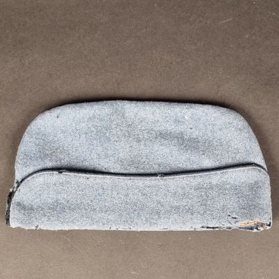 un gros plan d'un petit sac gris posé sur une surface marron