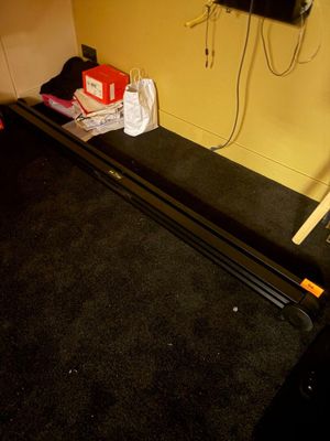 une photo d'une pièce avec un tapis de course et une télévision