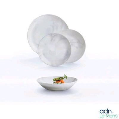 a white plate with a salad in it and a bowl with a carrot in it