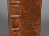 an old book with a leather cover sitting on top of a table