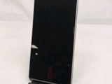 the back of a black cell phone sitting on top of a white table