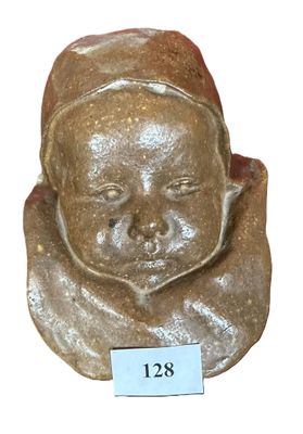 a small figurine of a baby with a name tag