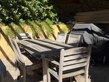 a table and chairs on the patio under a pergol roof