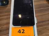 un téléphone portable noir posé sur une table, avec une étiquette de prix