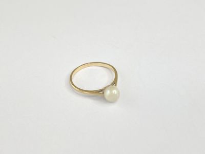 a close up of a ring with a pearl on it