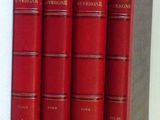 Quatre livres rouges sont empilés les uns sur les autres sur une étagère