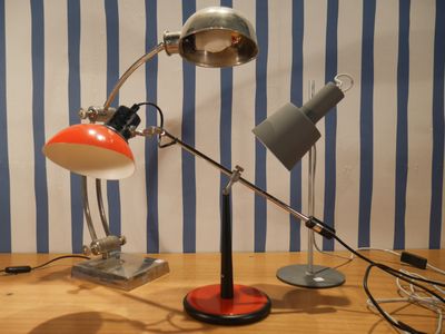 deux lampes posées sur une table, avec en arrière-plan un mur rayé de bleu et de blanc