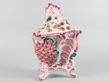 a pink and white vase with a bird on it