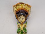 a ceramic figurine of a woman with a basket on her head