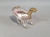 un objet en argent orné d'un cheval, posé sur une table