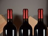 three bottles of red wine sitting on a table