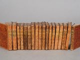 several old books are lined up in a row on a table