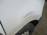 a close up of a white truck with a dirty tire