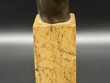 a close up of a statue of a woman ' s head on a wooden block