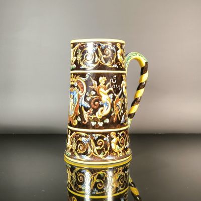 une tasse marron et jaune posée sur une table noire