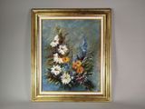 un tableau représentant des fleurs, dans un cadre doré, accroché au mur