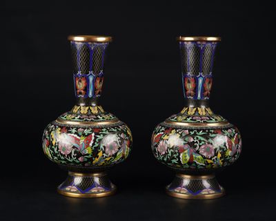 une paire de vases posés sur une surface noire, sur fond noir