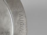 a close up of a silver plate with writing on it