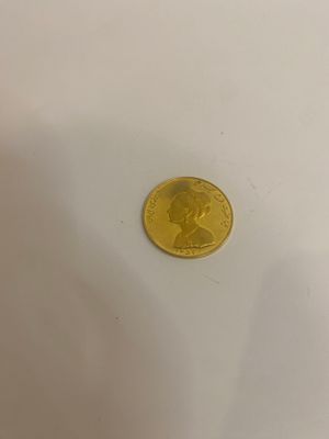 une pièce d'or posée sur une surface blanche