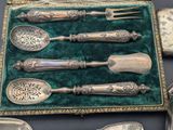 a lot of silver spoons and spoons in a case