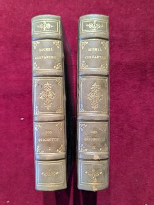 deux vieux livres posés sur une table recouverte d'un tissu rouge