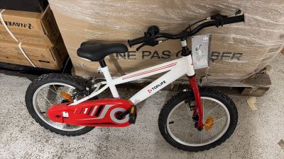 un vélo rouge et blanc posé à côté d'une boîte