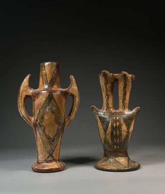 two brown vases sitting next to each other on a gray surface